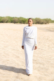 Person wearing a white outfit standing in a desert landscape