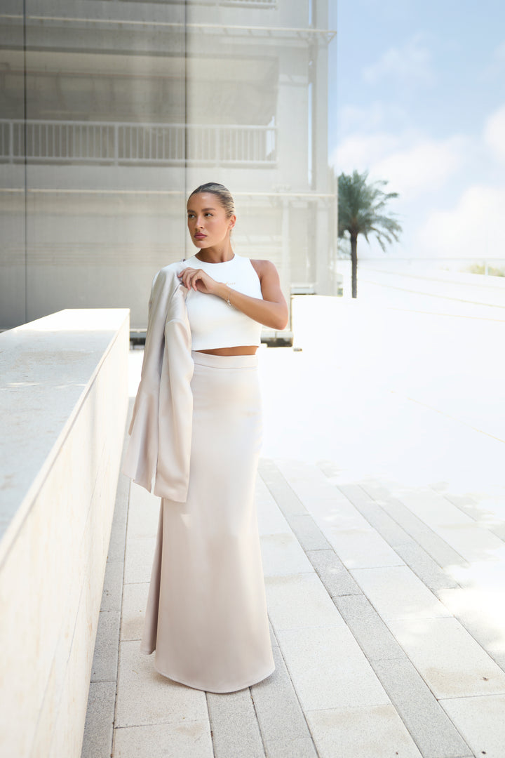 Woman in a white outfit standing on a modern architectural background