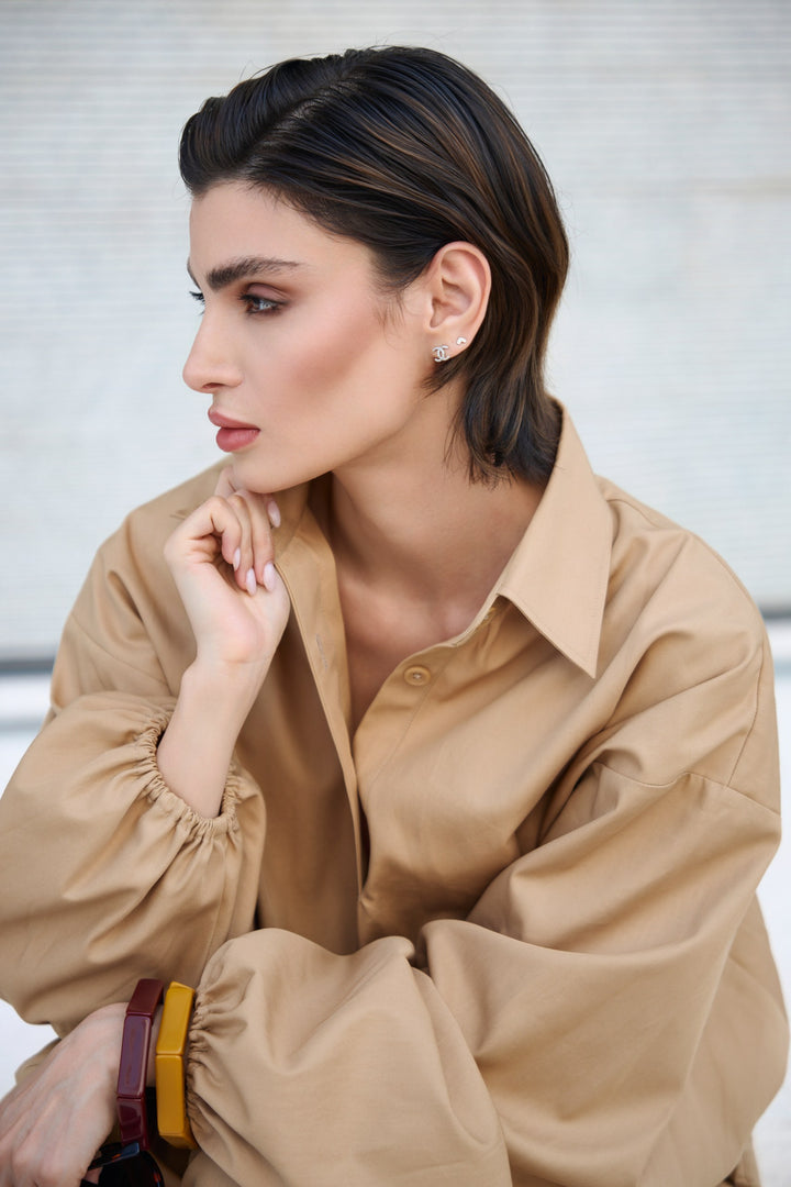 Woman wearing a beige shirt with a blurred background