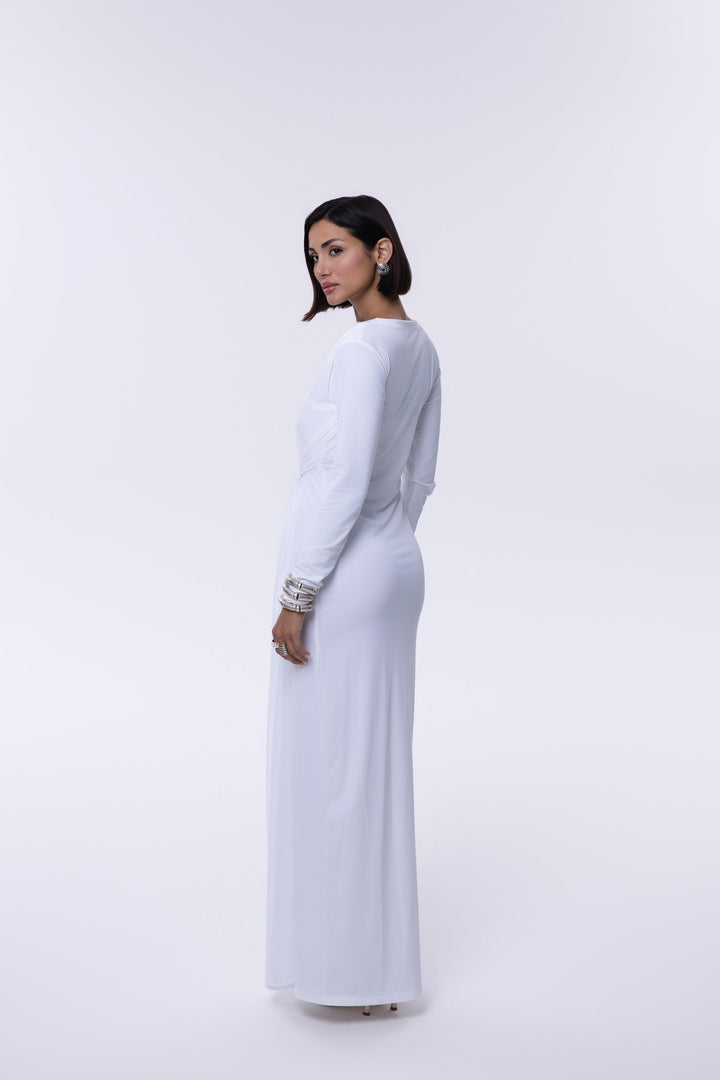 Woman wearing a long white dress against a white background