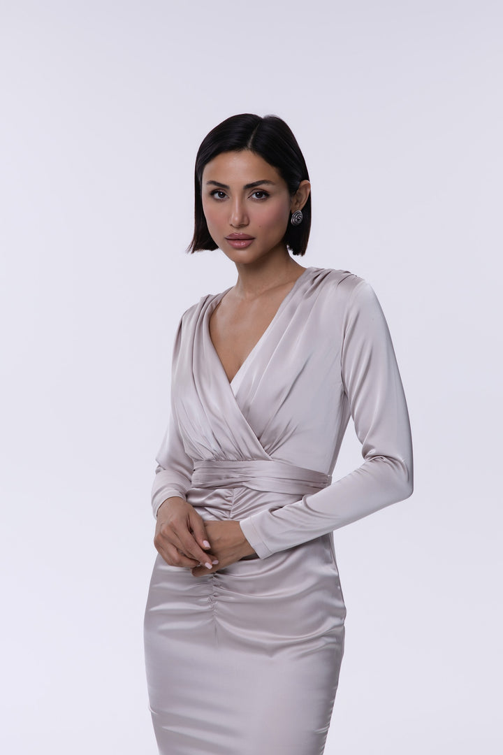 Woman wearing a light gray dress against a white background