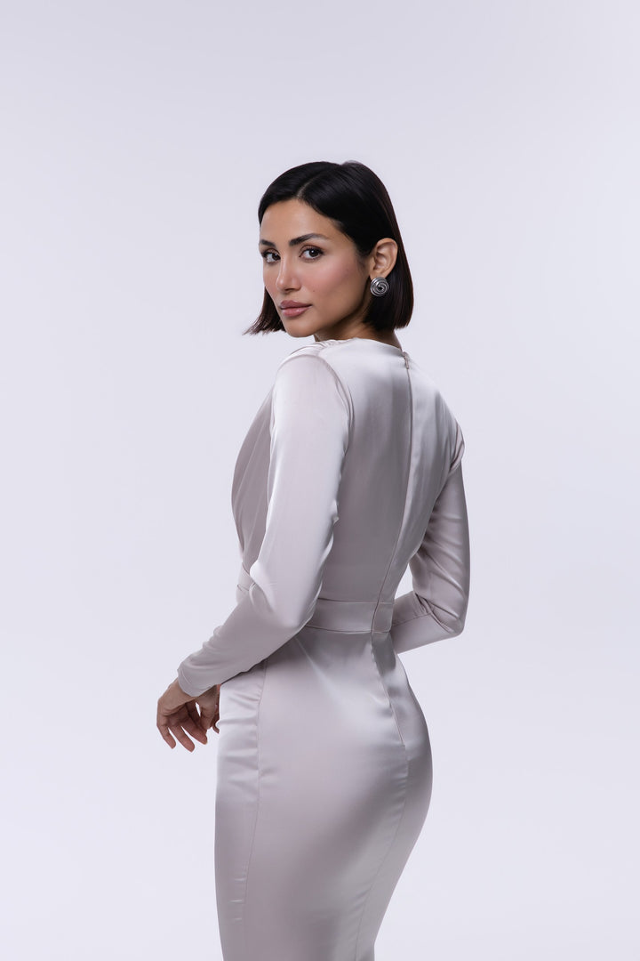 Woman wearing a fitted white dress against a plain background