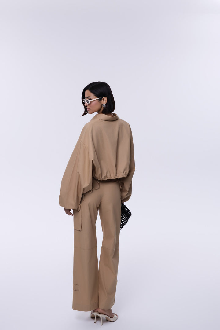 Person wearing a beige outfit on a white background