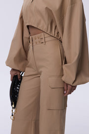 Person wearing a beige outfit with a white background