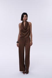 Woman wearing a brown jumpsuit on a white background