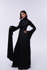 Woman wearing a black abaya on a white background