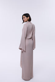 Woman wearing a long, light-colored dress against a white background