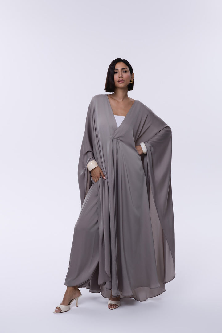 Woman wearing a gray abaya on a white background