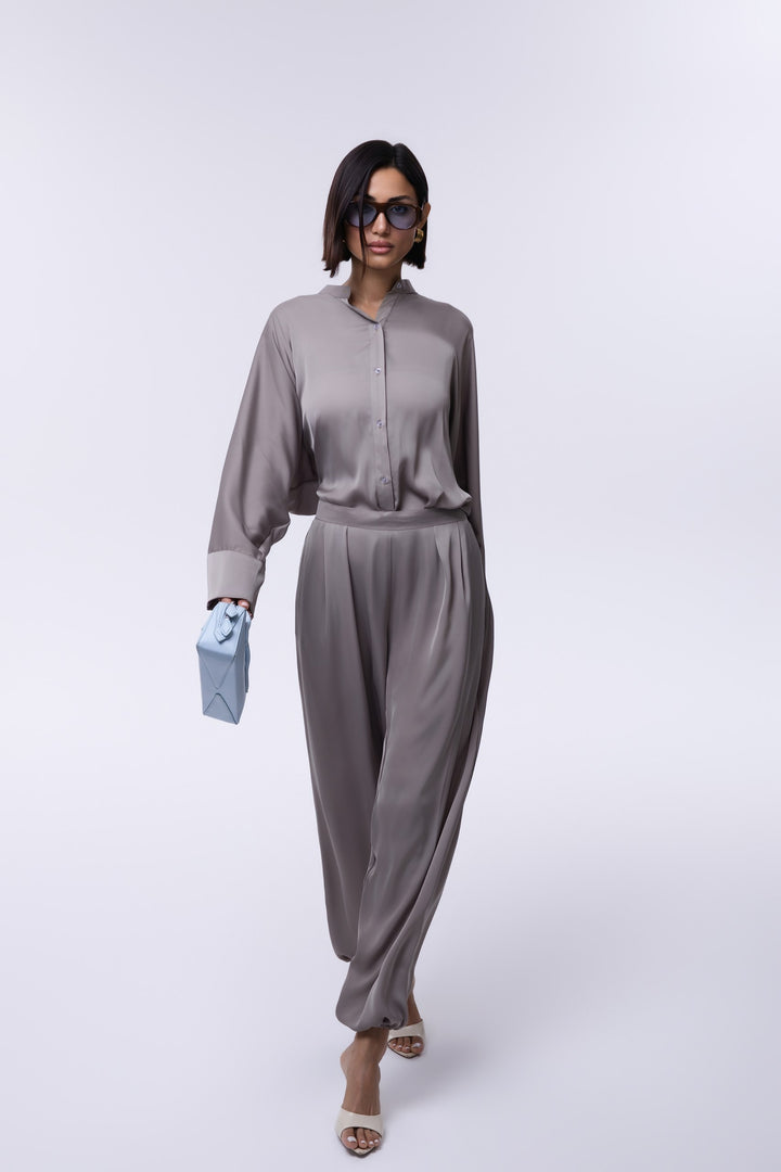 Woman wearing a gray jumpsuit on a white background