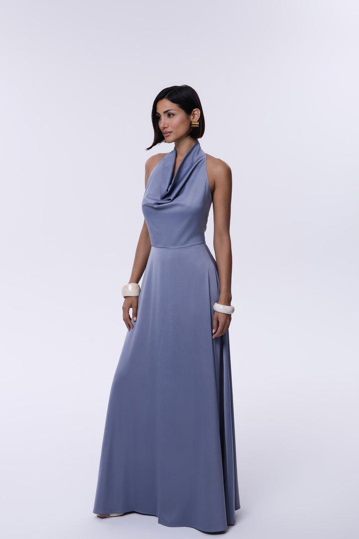 Woman wearing a long, light blue dress against a white background