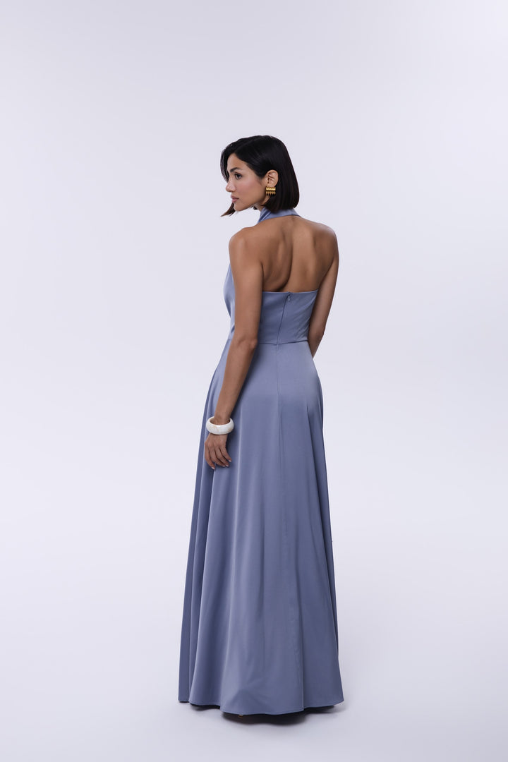Woman wearing a long, light blue dress against a white background