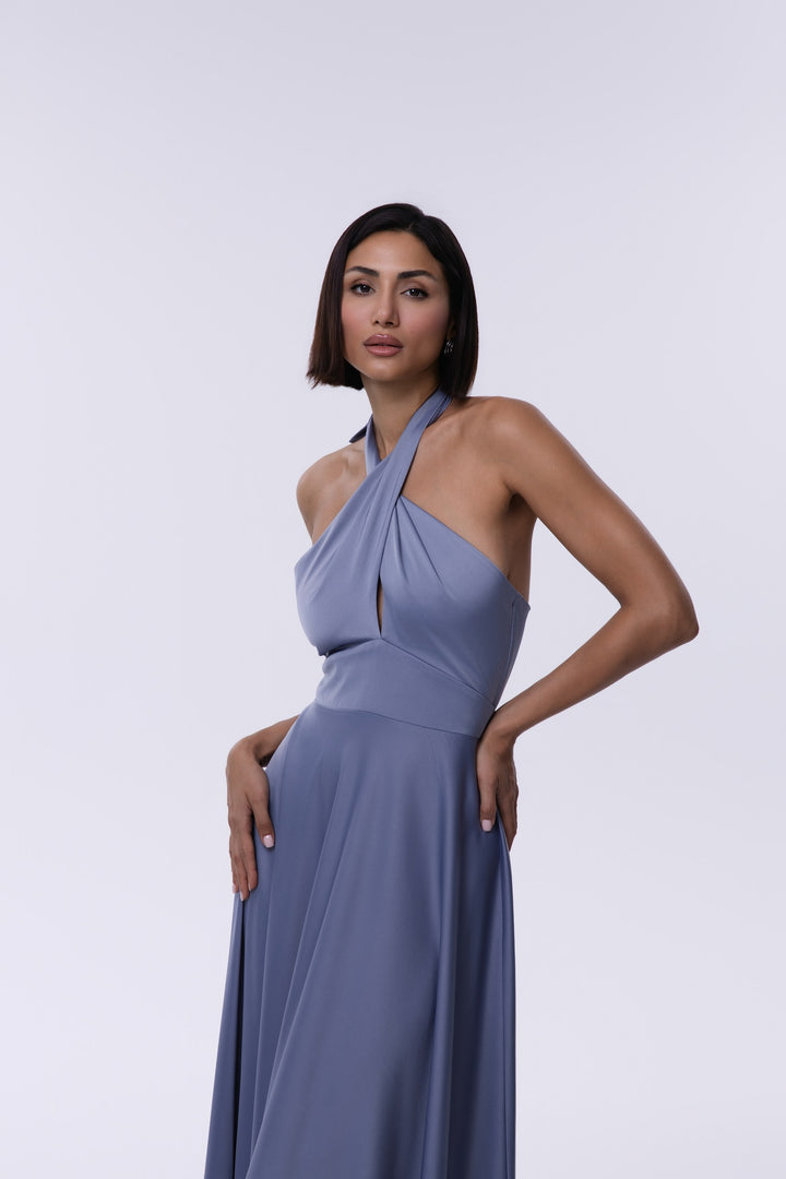 Woman wearing a light blue halter neck dress against a white background