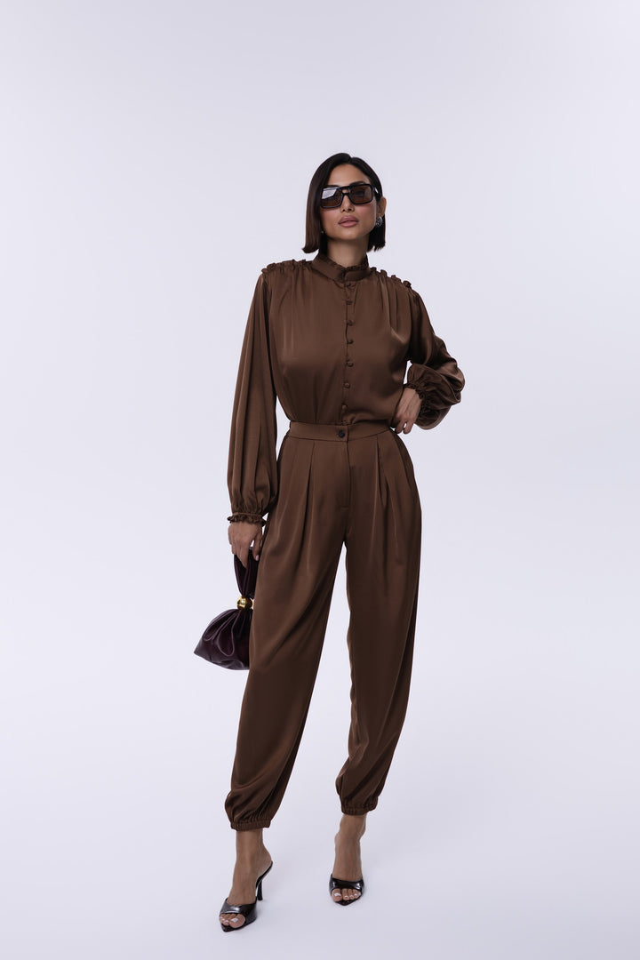 Woman wearing a brown jumpsuit on a white background