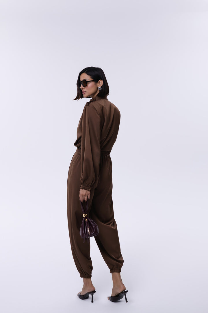Woman wearing a brown outfit with a white background