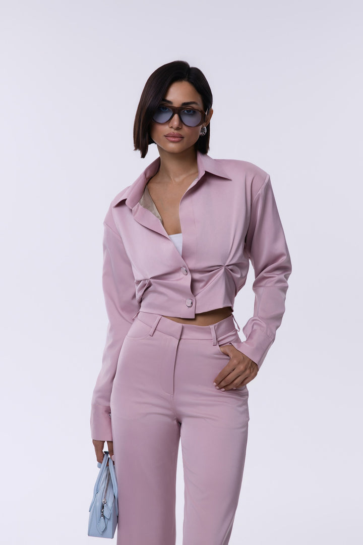 Woman wearing a pink outfit with sunglasses on a white background