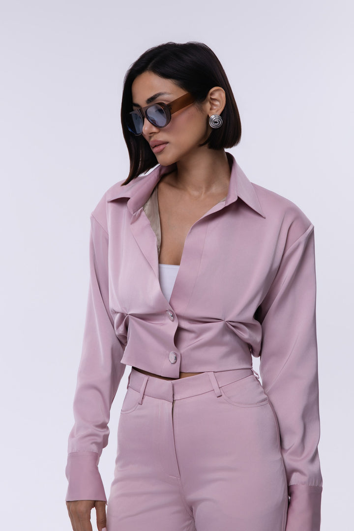Woman wearing a pink outfit with sunglasses on a white background