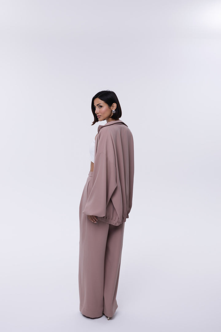 Woman wearing a mauve outfit on a white background