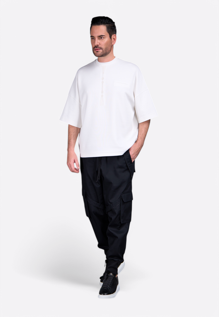 Model wearing white tassel T-shirt with premium cotton detail East Vibe
