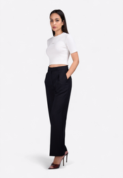 Model wearing white short sleeve crop top by East Vibe