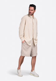 Model wearing beige long sleeve shirt by East Vibe