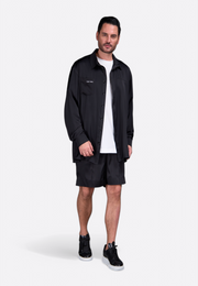Model showcasing tailored black silk shorts for men by East Vibe