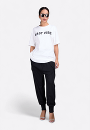 Model wearing EAST VIBE white T-shirt, front-side view – East Vibe
