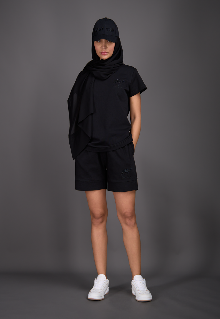 Model wearing black T-shirt and shorts, front view – East Vibe
