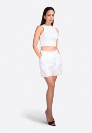 Model wearing off-white linen shorts in refined summer style East Vibe