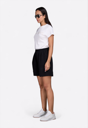 Model wearing short-sleeve off-white T-shirt, front side pose – East Vibe
