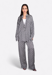 Front view of model wearing printed black trousers, East Vibe